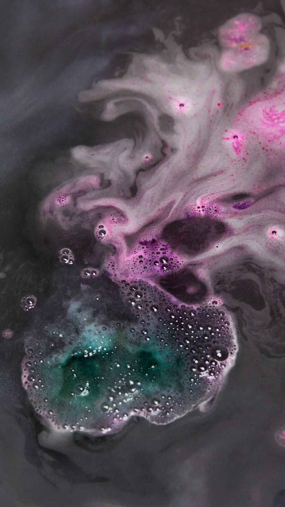 The World's Smallest Disco dissolves in the bath leaving a thick dark blanket of black sparked with vibrant swirls of teal and pink. 