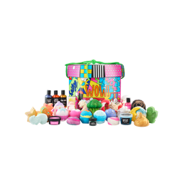 WOW! A large, deep, octagonal-shaped gift box with a lid. It is designed with bright, vivid, pop-art-style illustrations and tied with a green rope. Thirty-one Lush Christmas-themed products sit in front of the box. 