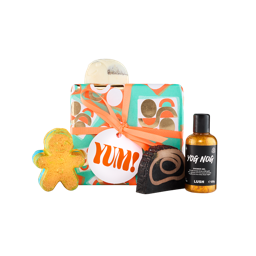 Yum! A square gift box wrapped in teal paper with orange, gold and white retro patterns, tied with an orange ribbon and gift tag. Four included Lush products sit on and around the gift box.